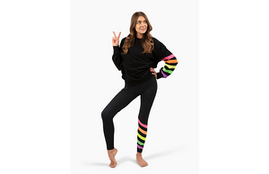 Model wearing matching black activewear loungewear set with neon stripes