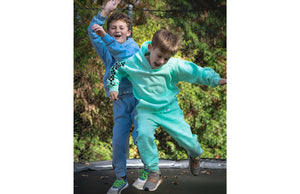 Boys on trampoline wearing matching sweatsuit with checkerboard print