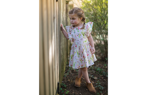 Girl modeling pink vintage inspired dress with plants print