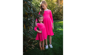 Sisters modeling hot pink stretch velvet twirly dresses